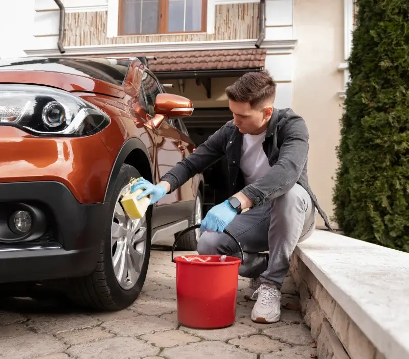 Lavage auto à domicile Saint-Georges-le-Gaultier : professionnel intervenant sur un véhicule